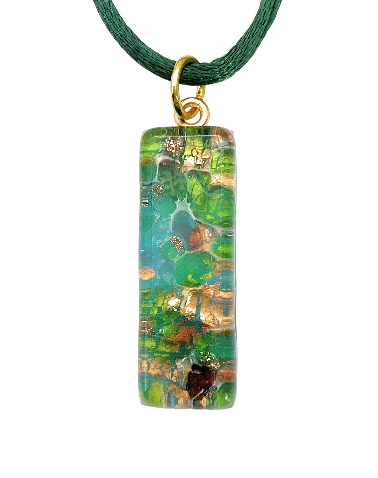 The Murano Passion MGPL9 Pendant, measuring 3cm x 1cm, features swirling patterns in green, brown, and gold that resemble an abstract landscape or foliage. This rectangular pendant is crafted with a glossy, polished finish and hangs elegantly from a dark green cord, with a small gold loop attachment highlighting the allure of handmade jewelry.