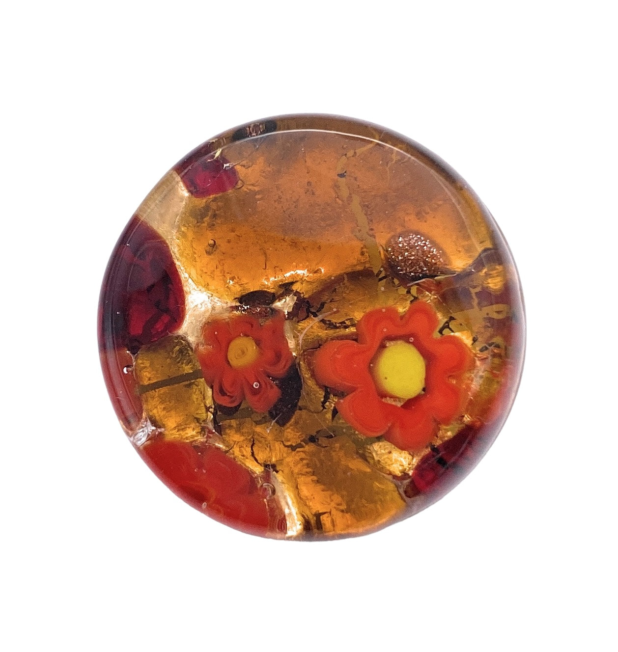 The Murano Glass Brooch with Millefiori on a Gold Leaf Base by Murano Passion showcases embedded red and orange floral designs against a golden backdrop. The flowers, reminiscent of Venetian artistic heritage, have distinct petal shapes with yellow centers surrounded by abstract patterns.