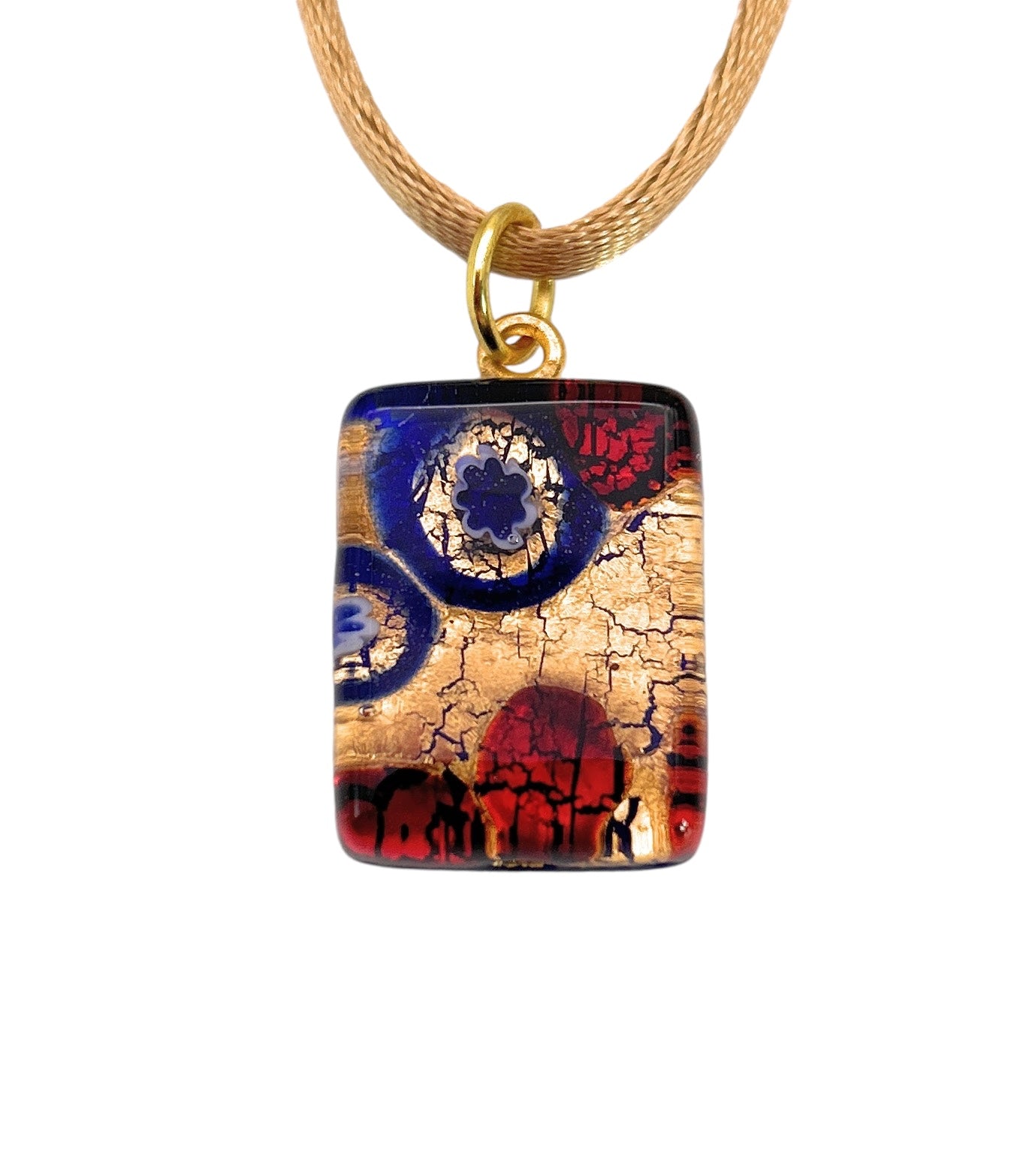 The Murano Passion Millefiori Pendant (MGPP27) is a dainty rectangular piece measuring 2 cm by 1.5 cm, featuring an abstract design with smooth surfaces. It beautifully showcases a blend of blue and red circular patterns on gold leaf, reminiscent of cracked textures found in traditional Millefiori pieces. This exquisite Murano Glass Pendant hangs elegantly from a light brown cord.