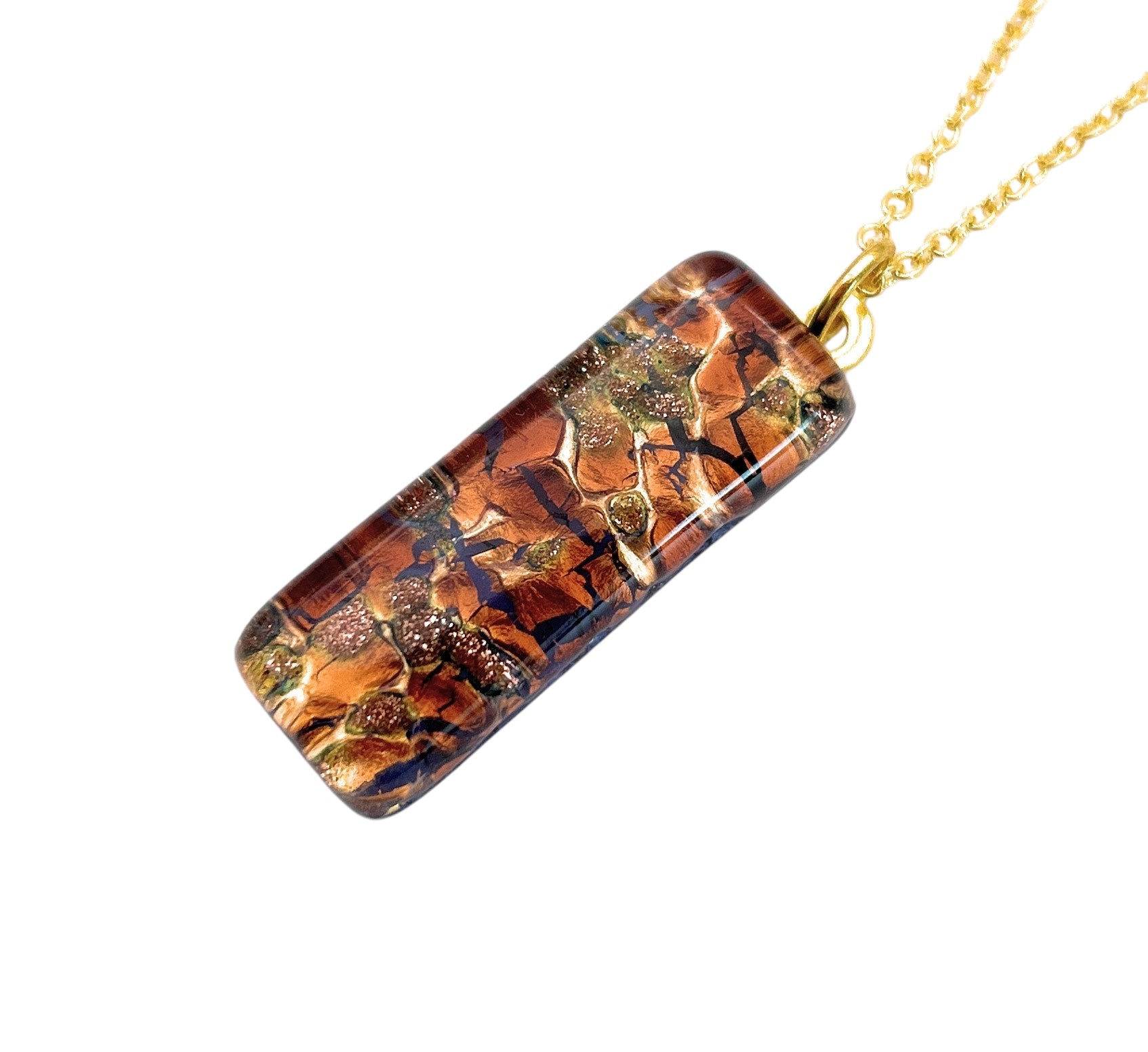 Introducing the exquisite Murano Passion pendant: a rectangular 3cm x 1cm Murano Glass Pendant made using gold leaf, featuring a mesmerizing mosaic design in shades of brown, gold, and black with a glossy finish. This piece of Murano Glass Jewellery comes complete with a Certificate of Authenticity.