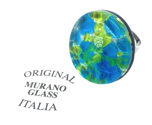 This authentic Murano Passion ring features a bold, 3cm chunky design with a mesmerizing blend of green and blue millefiori patterns on silver leaf. On the left, the text "Original Murano Glass Italia" is elegantly displayed in black lettering, honoring its artisanal creation in Venice.