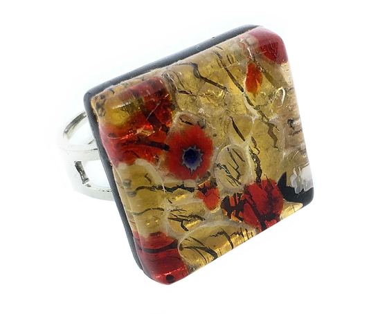 This bold statement ring by Murano Passion, featuring a genuine Murano glass piece handmade in Venice, Italy, presents an artistic abstract design with vibrant red, blue, and gold swirls. The colorful patterns on this Millefiori Flower Ring atop gold leaf resemble artistic brushstrokes for a unique and eye-catching accessory.