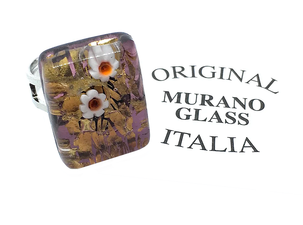 A rectangular Murano Glass Ring by Murano Passion features a Millefiori floral design in white and orange set against a purple background with gold leaf. The words "Original Murano Glass Italia" are elegantly displayed beside the ring, showcasing its authenticity and exquisite craftsmanship.