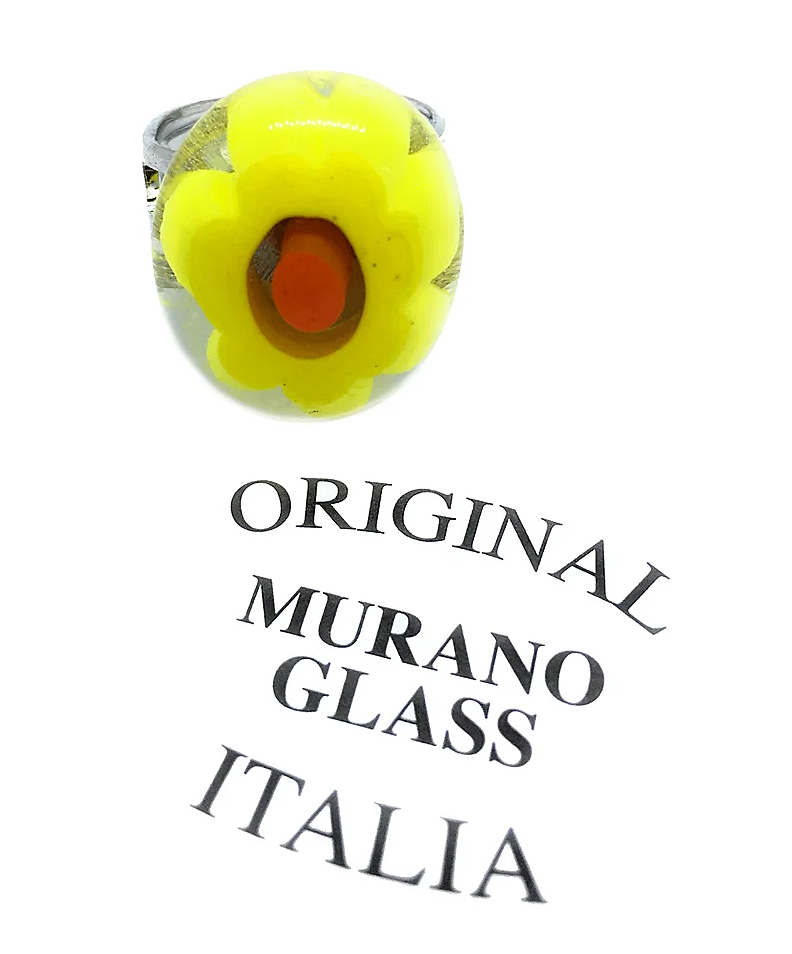 Displayed is a Murano Passion Millefiori Flower Ring, featuring an authentic Murano Glass design with a yellow flower highlighted by an orange center. Handmade in Venice, it proudly features the "ORIGINAL MURANO GLASS ITALIA" text in an arched layout below. The ring measures 2cm x 1.6cm.