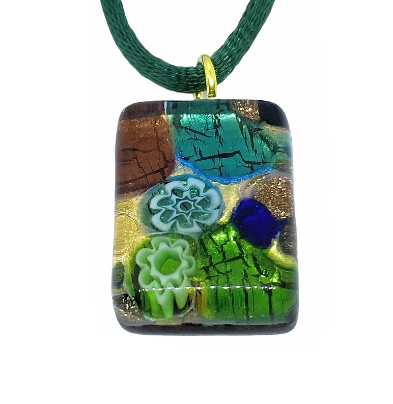 The Murano Passion pendant, "Murano Glass Pendant on Gold Leaf - Dainty 2cm x 1.5cm," showcases a textured rectangular design in shades of blue, green, and gold with floral patterns in relief. Reminiscent of Millefiori art, this vibrant piece hangs on a dark green cord, offering an artistic accessory.