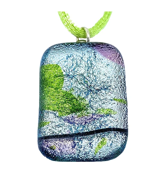 A rectangular pendant from Calon Glass, meticulously crafted from handmade dichroic glass with a silver base measuring 3cm x 2cm, hangs elegantly on a vibrant green cord. Its colorful, textured surface beautifully displays an abstract artistic design featuring captivating shades of blue, purple, and green.