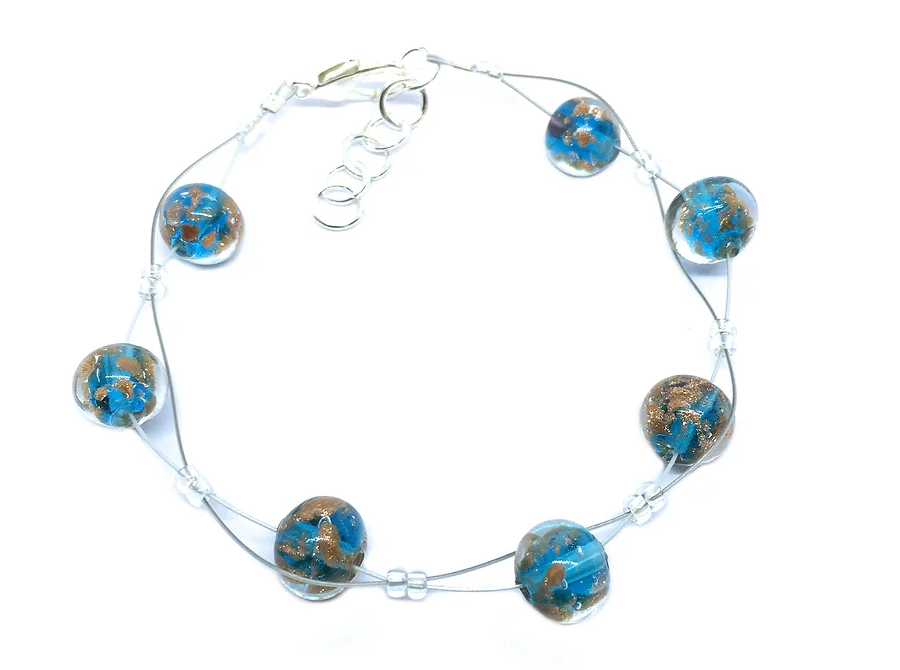 The Murano Passion Beaded Bracelet features dainty 8mm Aqua Blue beads with a unique marbled pattern of blue and brown. These beads are linked by a slender wire with clear bead spacers, and the bracelet is secured with a lobster clasp attached to adjustable extension rings, making it an authentic piece of artisanal Murano Glass jewellery.