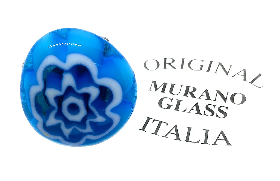 Displayed beside the gently curving text "Murano Passion," a Murano Glass Ring showcases its vibrant blue hue and intricate white flower pattern, echoing the Millefiori style. This exquisite piece beautifully embodies the rich Venetian artistic heritage in a minimalist setting.