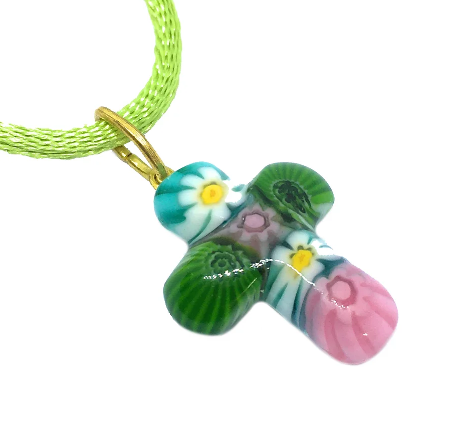 The Murano Passion Murano Glass Cross Pendant, featuring vibrant Millefiori flower patterns in pink, green, and white, hangs elegantly from a thin green cord. Each piece comes with a Certificate of Authenticity to guarantee its unique craftsmanship.