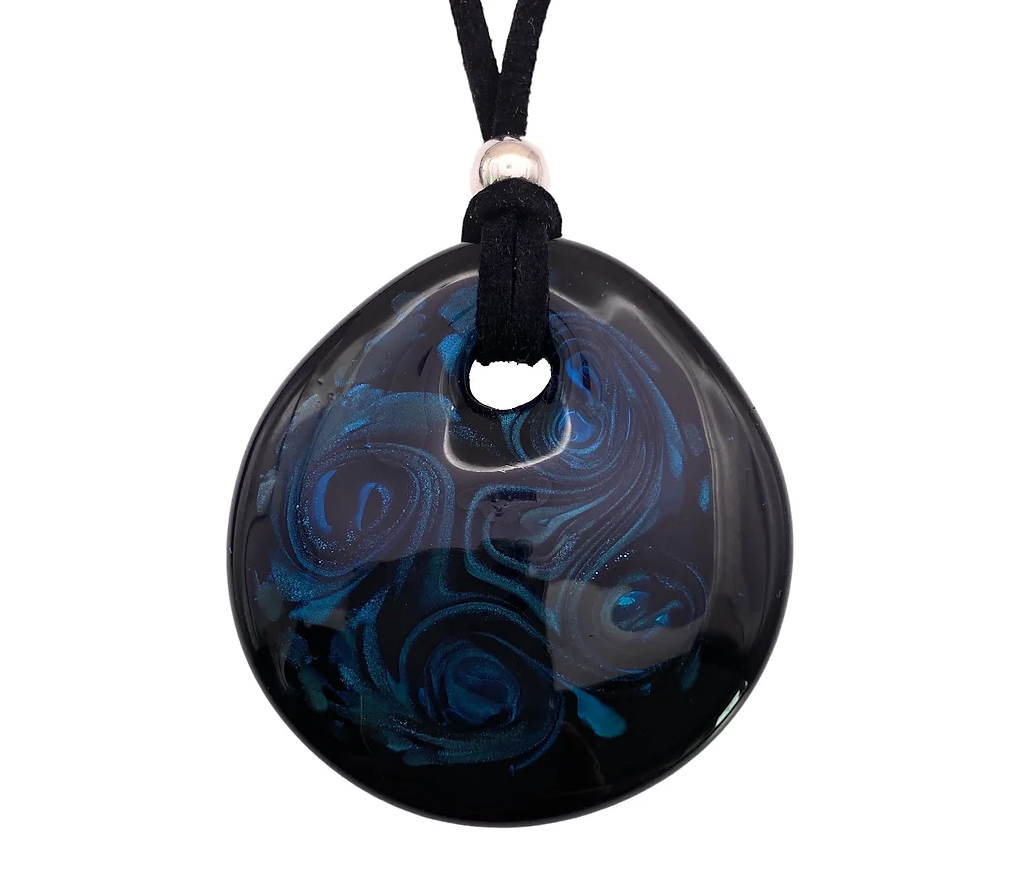 This exquisite Murano Passion Aventurine Pendant, made of Murano glass, showcases a teardrop shape with a glossy black finish and swirling blue patterns. Measuring 5.5cm by 5cm, it elegantly hangs from a black cord that is adorned with a silver bead at the top.