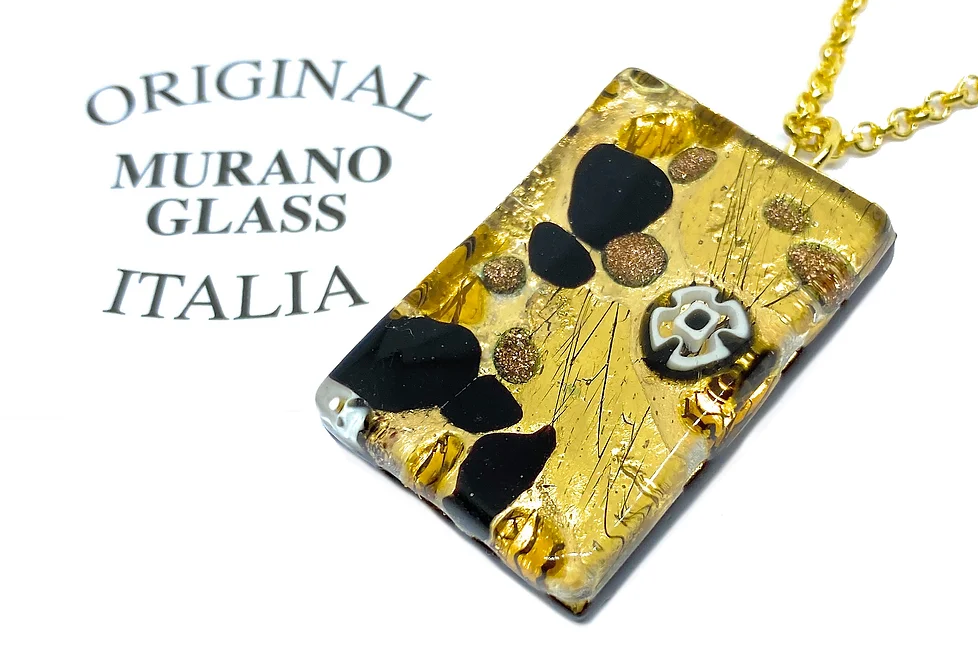 Introducing the exquisite Murano Passion Millefiori Pendant with Gold Leaf, measuring 3cm x 2cm. This stunning rectangular pendant showcases a gold, black, and white floral design and elegantly hangs from a gold chain. Certified with a Certificate of Authenticity, it proudly declares "Original Murano Glass Italia.