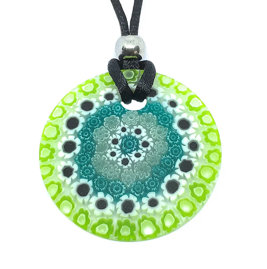 The Murano Passion Murano Glass Pendant, crafted with Millefiori Flowers and boasting a 4cm diameter, features an exquisite round design in vibrant floral and geometric patterns with shades of green, teal, and black. This authentic piece hangs gracefully from a black cord accented by a silver bead.