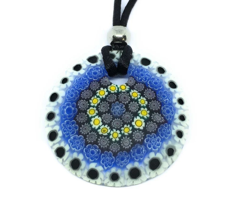 The Murano Glass Pendant made with Millefiori Flowers by Murano Passion beautifully captures the essence of Venetian artistic heritage. It features a circular design adorned with intricate floral patterns in blue, white, and yellow. Complete with a black lace cord and silver bead attachment, it exemplifies exquisite craftsmanship.