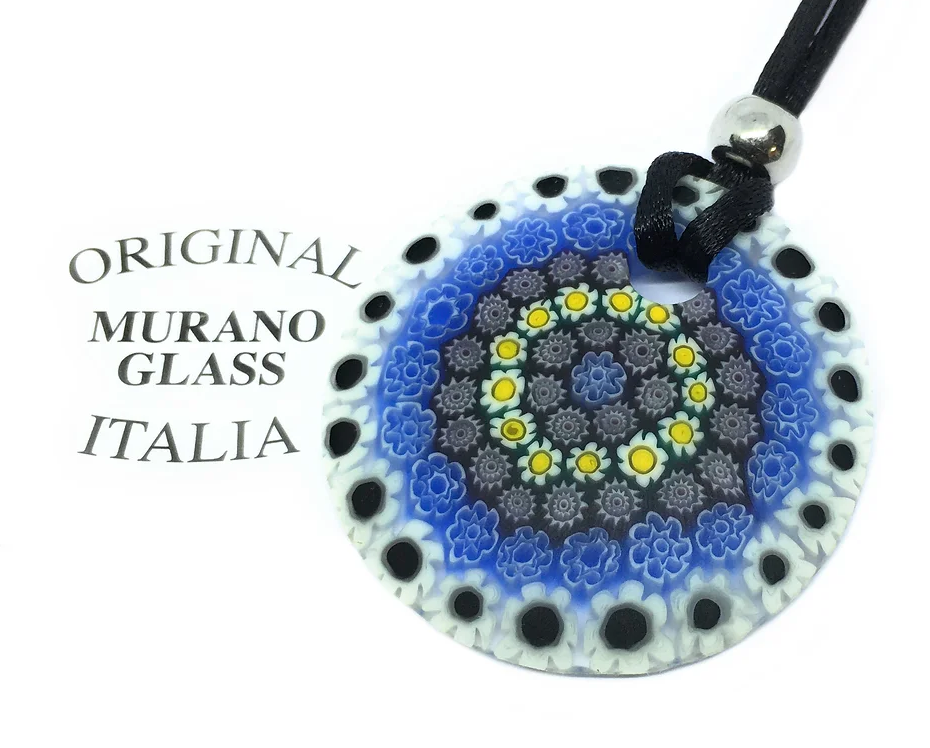 The Murano Passion Murano Glass Pendant, featuring Millefiori Flowers, displays exquisite floral patterns in blue, black, and yellow set against a white background. It beautifully captures the essence of Venetian artistic heritage. The pendant, with a diameter of 4cm, is attached to a black cord and prominently features the inscription "Original Murano Glass Italia" next to it.