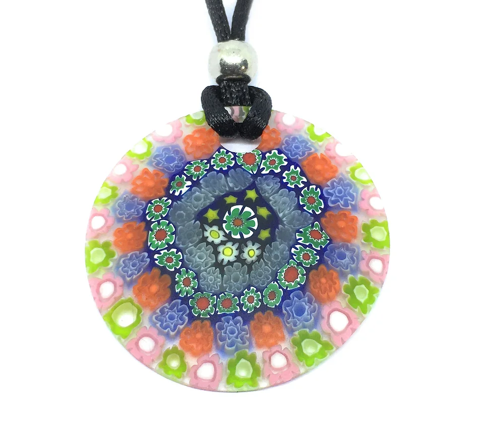 The Murano Passion pendant, crafted with genuine Murano glass, highlights a colorful Millefiori floral mosaic pattern in pink, orange, blue, and green. With its roots in Venetian artistic heritage, this 4cm diameter piece is elegantly complemented by a black cord threaded through a silver bead at the top.