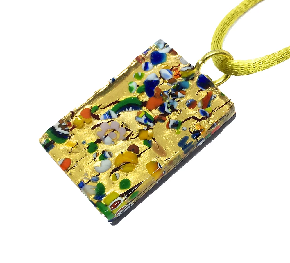 The Murano Passion Murano Glass Pendant, crafted with Millefiori on Gold Leaf and measuring 3cm x 2cm, boasts a colorful abstract design featuring multicolored fragments on a gold background. It dangles from a yellow cord, highlighting vibrant Millefiori patterns in red, blue, green, and white.