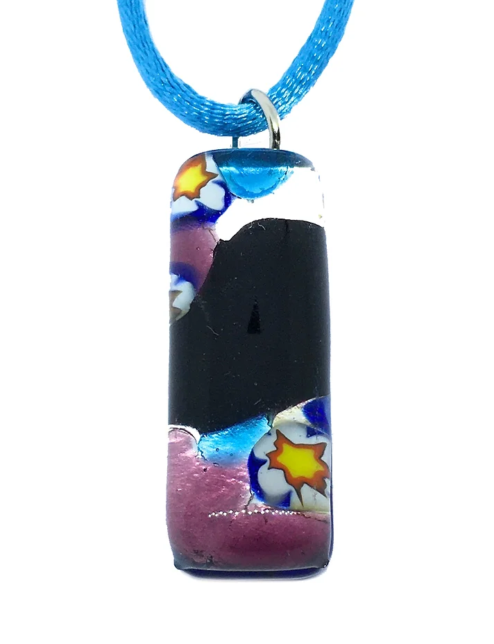 A rectangular Murano Glass Pendant from the Murano Passion brand, measuring 3cm x 1cm and designed on a blue cord with silver leaf, showcasing a black background adorned with abstract designs in blue, white, pink, and yellow star-like patterns.