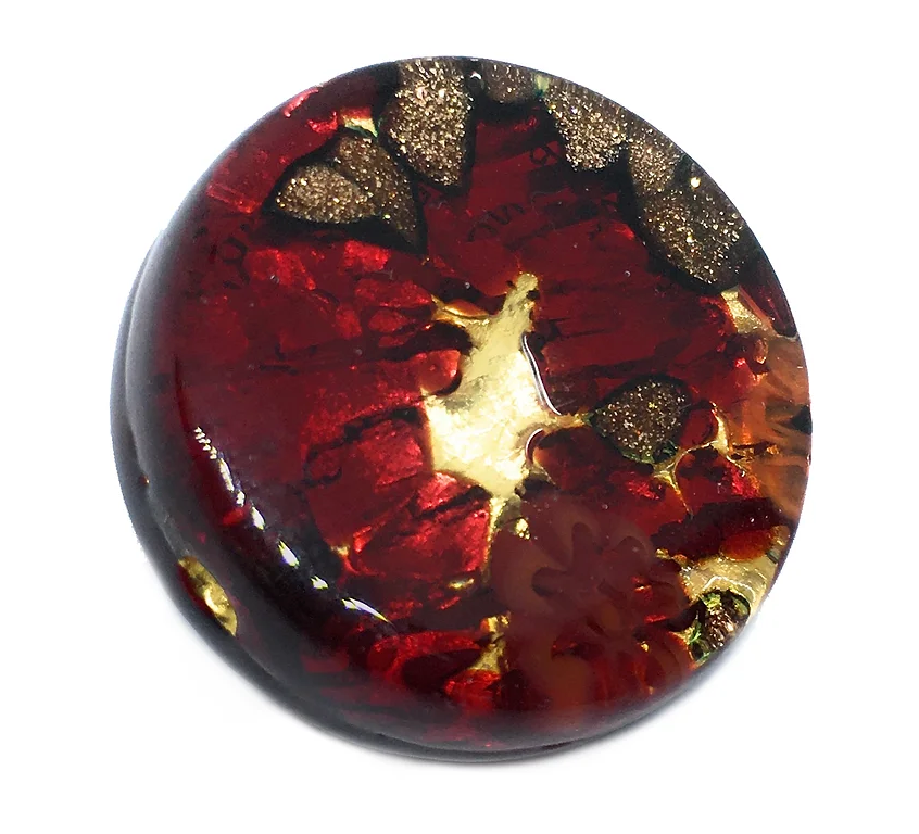 A round brooch from Murano Passion evokes Venetian artistic heritage, featuring a glossy red and gold resin with abstract floral patterns and metallic flecks. This Murano Glass Brooch, measuring 2.4 cm and set on a gold leaf base, creates a shimmering effect reminiscent of handmade artistry, highlighted by the rich interplay of colors and shapes within the clear resin.