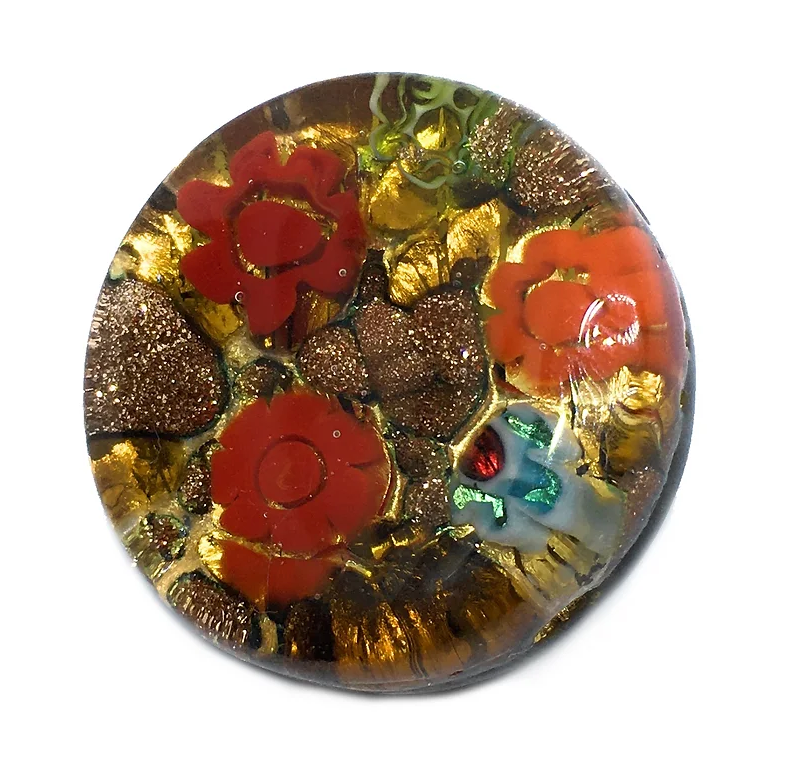 A round, domed paperweight from Murano Passion showcases deeply embedded red and orange floral designs with gold specks and hints of green, boasting a glossy surface that reflects the vibrant Venetian artistic heritage captured in its intricate details.