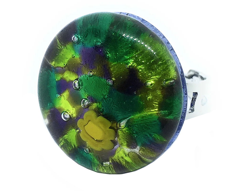 Introducing the Murano Passion Murano Glass Ring, a chunky statement piece measuring 2.5cm. This round ring boasts a vibrant green and purple pattern, adorned with a yellow flower at its center. Handmade in Murano, its glossy surface captures light beautifully, highlighting the exquisite artistic design and authentic Murano craftsmanship.