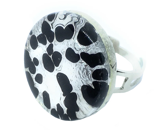 The Murano Passion chunky statement ring, with its 2.5cm face, features a round design with a black and white abstract art pattern of irregular black shapes on a white background. The silver band beautifully complements the Genuine Murano Glass, reflecting centuries of Venetian artistic heritage.