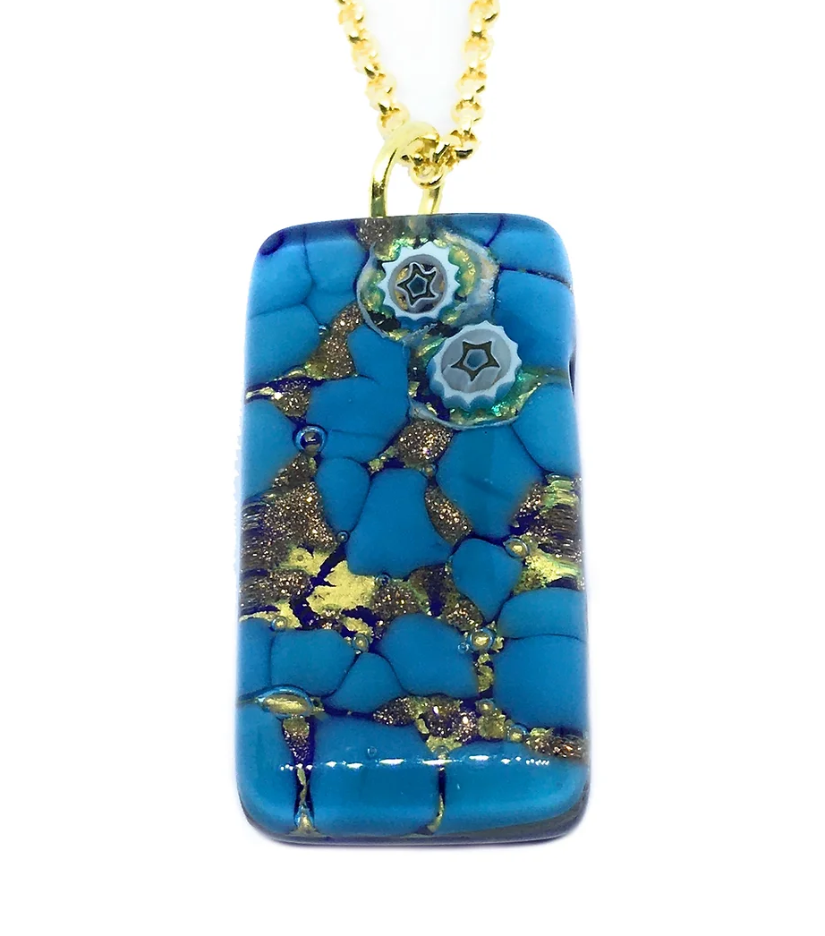 The Murano Passion's Millefiori Pendant beautifully showcases a rectangular blue piece with intricate gold veins and two delicate star-shaped designs, all suspended elegantly from a shimmering gold chain. This exquisite Murano Glass Pendant measures 3cm by 1.5cm and comes with a Certificate of Authenticity, presented against a pristine white background.