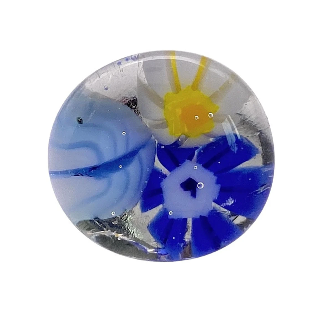 The Flower Ring by Calon Glass, also known as the Millefiori Ring (CGR4), beautifully features intricate designs with a white flower and yellow center, a deep blue flower, and abstract blue and white swirls on a translucent glass background.