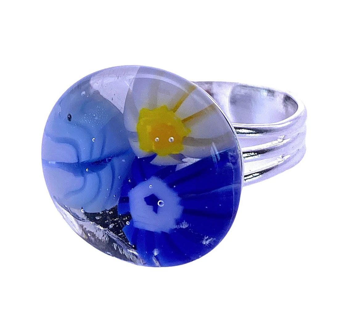 The Calon Glass Flower Ring, Millefiori Ring (CGR4), boasts a handmade glass face with abstract blue and white patterns, beautifully accented by a Millefiori-style yellow flower design.