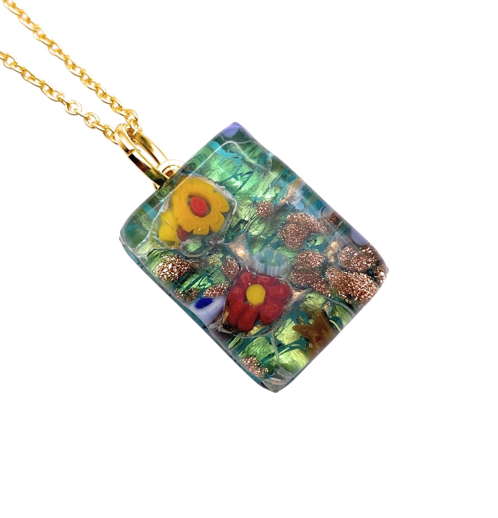 The Murano Glass Pendant, Millefiori Flower Pendant on Gold Leaf by Murano Passion, features stunning flower patterns in red, yellow, and green adorned with copper-like glitter. This exquisite 2cm x 1.5cm piece also includes a Certificate of Authenticity for genuine Murano Glass Jewellery.