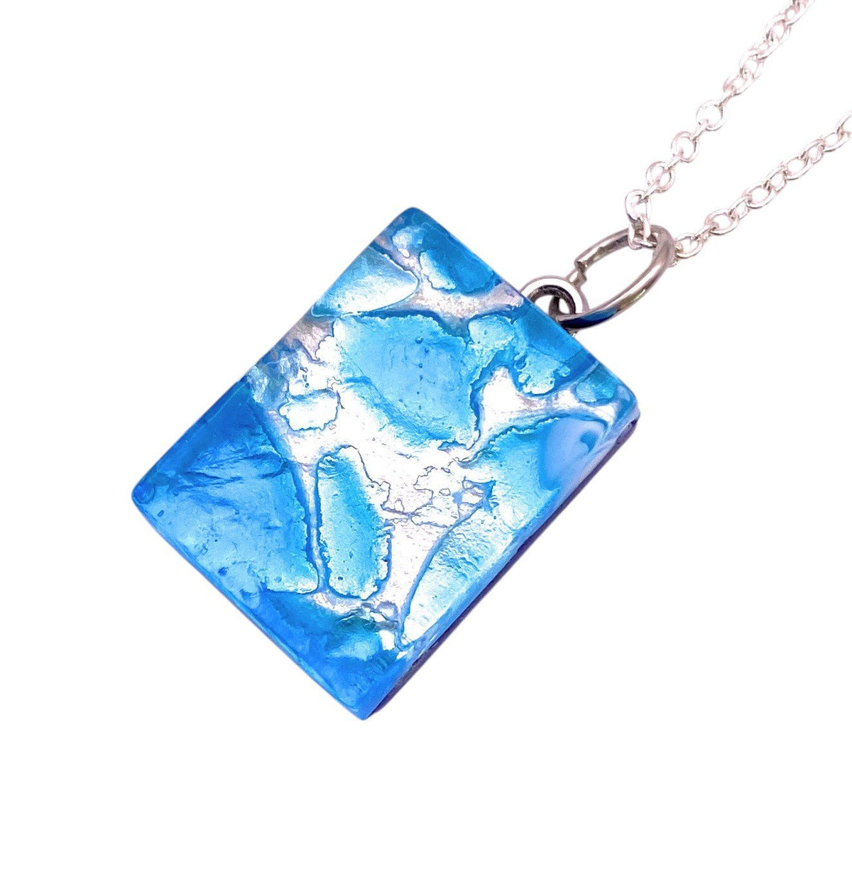 A dainty 2cm x 1.5cm Sky Blue Murano Glass Pendant on Silver Leaf by Murano Passion, featuring delicate silver and white crackle patterns, suspended from a thin silver chain.