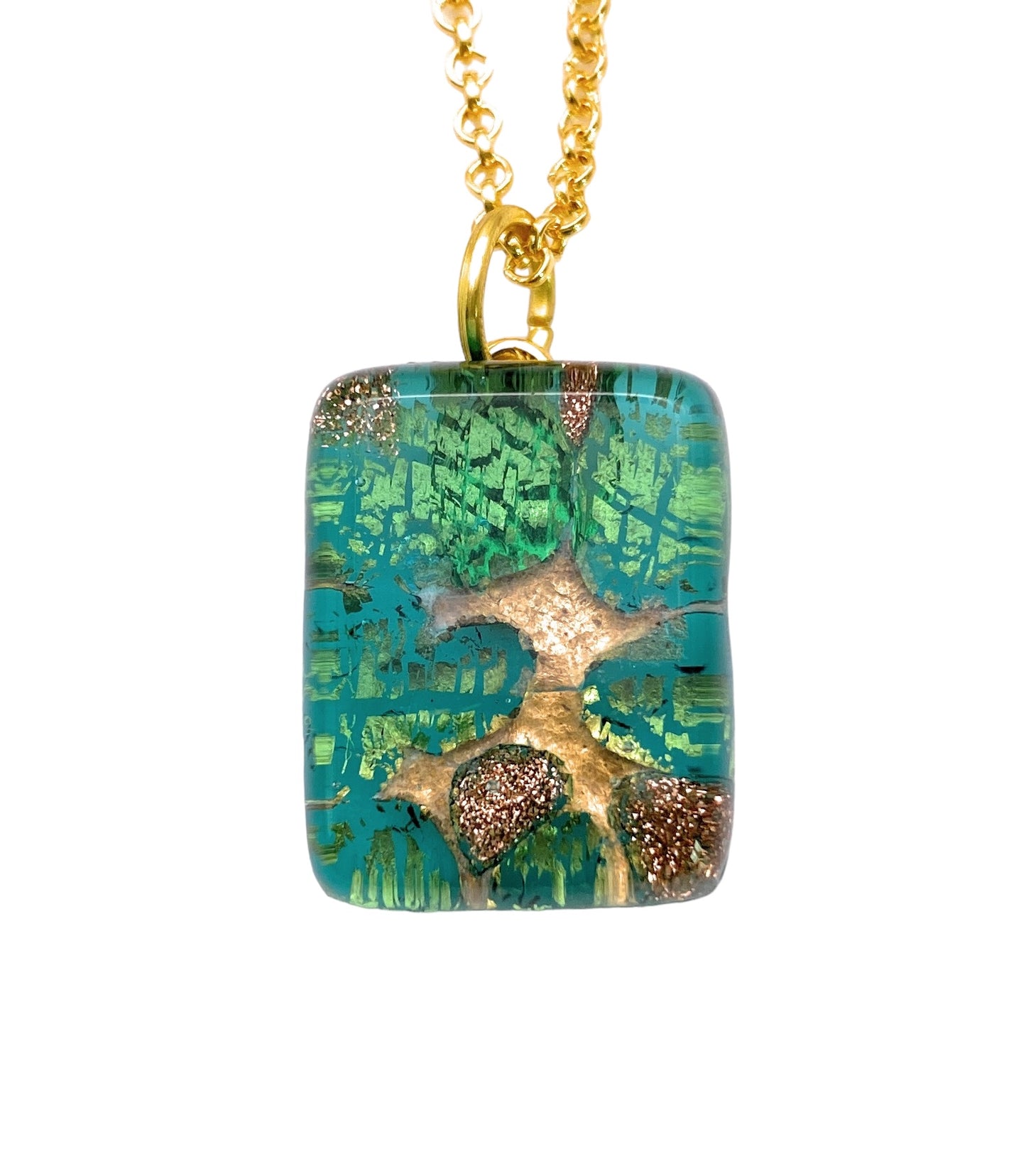 The Murano Passion Murano Glass Pendant, Green on Gold Leaf (MGPP6), highlights a golden tree design hanging from a gold chain. The background merges green and blue shades, offering texture and vibrancy. This 2cm x 1.5cm piece comes with a Certificate of Authenticity, capturing the elegance of Murano Glass Jewellery.