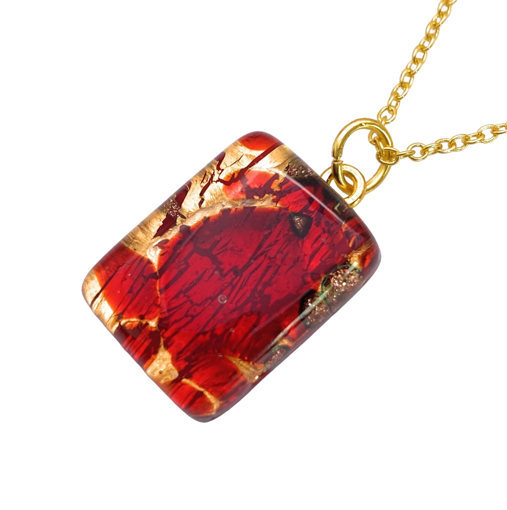 The Murano Passion Murano Glass Pendant on Gold Leaf showcases a brilliant red and gold crackled design in a dainty 2cm x 1.5cm rectangular shape, elegantly suspended from a delicate gold chain. Complete with a Certificate of Authenticity, this piece embodies the timeless allure of Murano Glass Jewellery, adding a touch of sophistication to your collection.