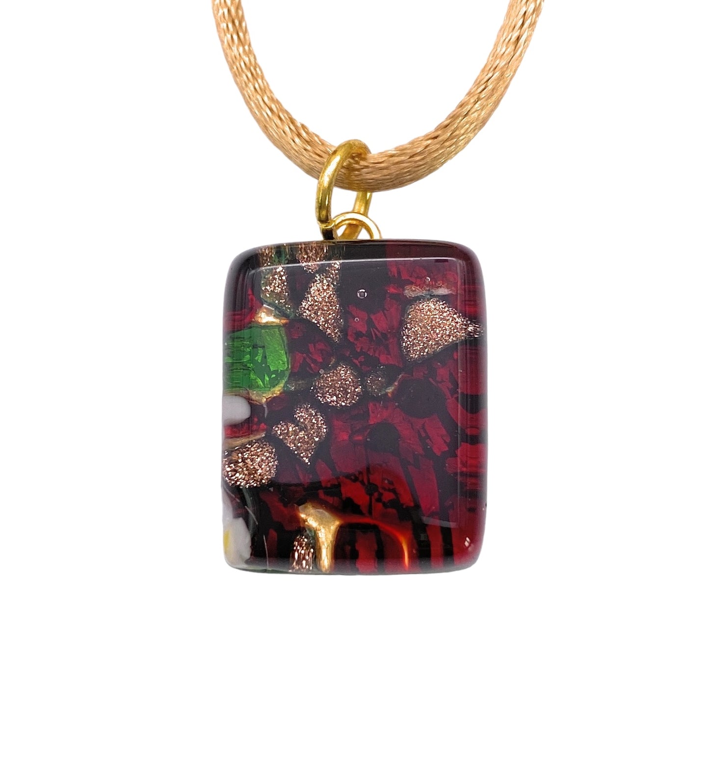 A Murano Passion pendant, known as the Murano Glass Pendant, Red on Gold Leaf - Dainty 2cm x 1.5cm (MGPP14), showcases an elegant square design featuring abstract red, black, gold, and green patterns. It hangs from a golden woven cord and boasts an intricate mix of swirls and specks that enrich the glossy surface with texture. This exquisite piece is accompanied by a Certificate of Authenticity.